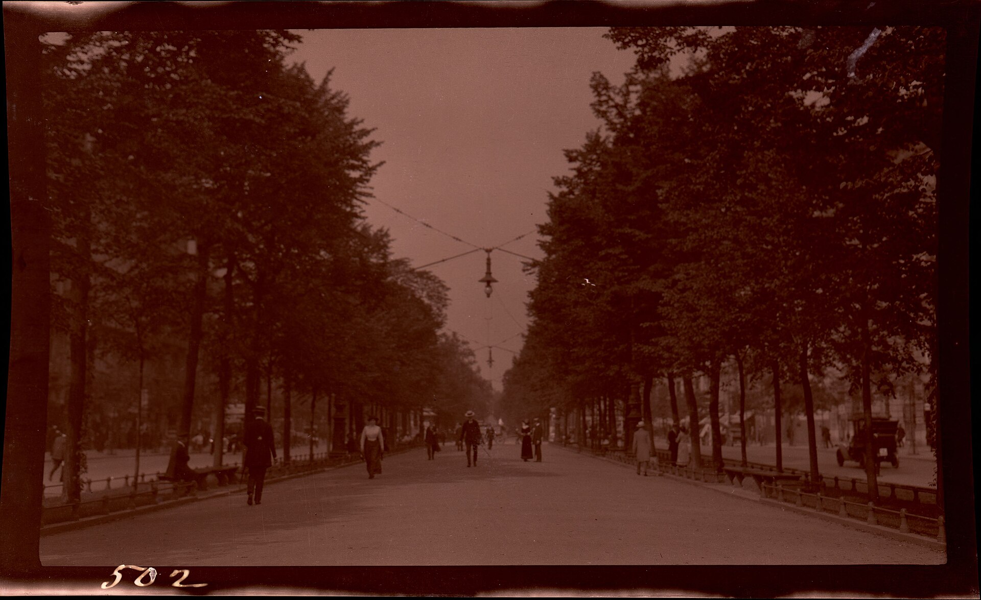 Pedestrians stroll down Unter den Linden, Berlin's lime-tree lined boulevard, which runs eastward from the Brandenburg Gate. Lights hang …